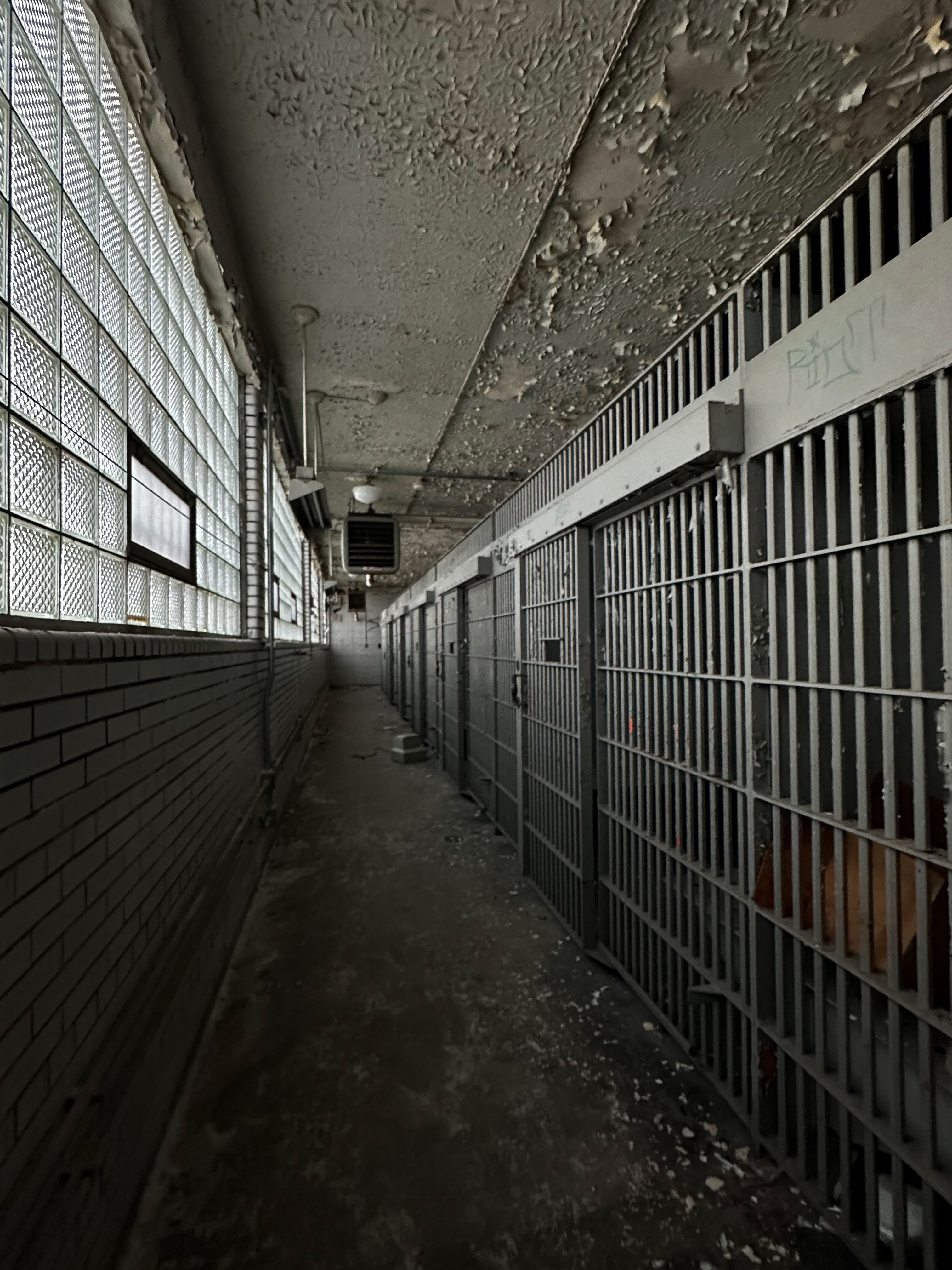 Row of jail cells in an abandoned police station corridor